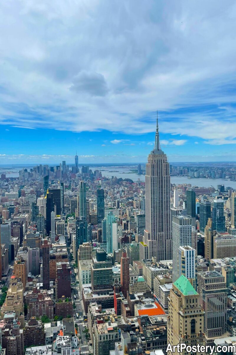 poster new york featuring a panoramic aerial view of Manhattan with the Empire State Building and cloudy blue sky